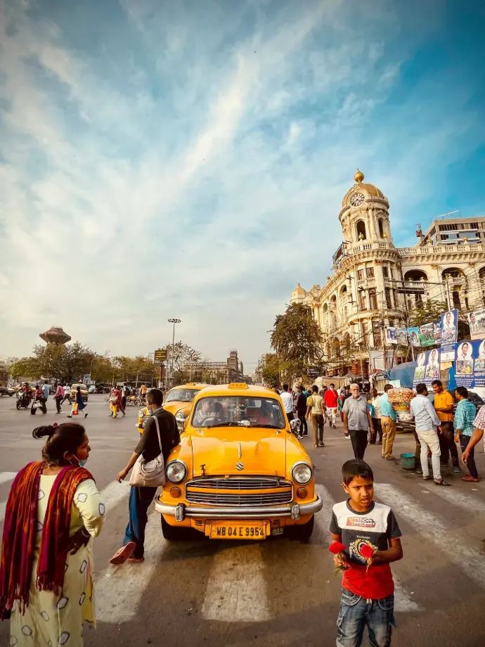 a group of people standing around a yellow car